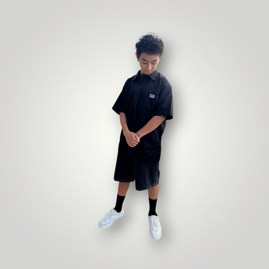 KA'EO x Ben Davis black poly-cotton twill work shirt with quarter-zip and chest pockets. Model is wearing shorts and sneakers.