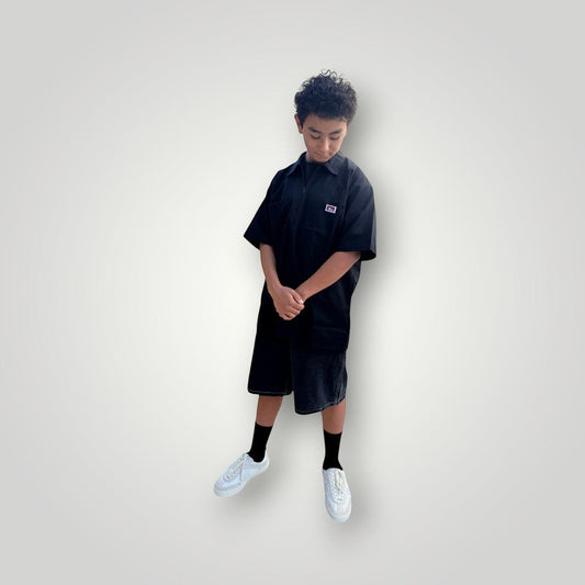 KA'EO x Ben Davis black poly-cotton twill work shirt with quarter-zip and chest pockets. Model is wearing shorts and sneakers.
