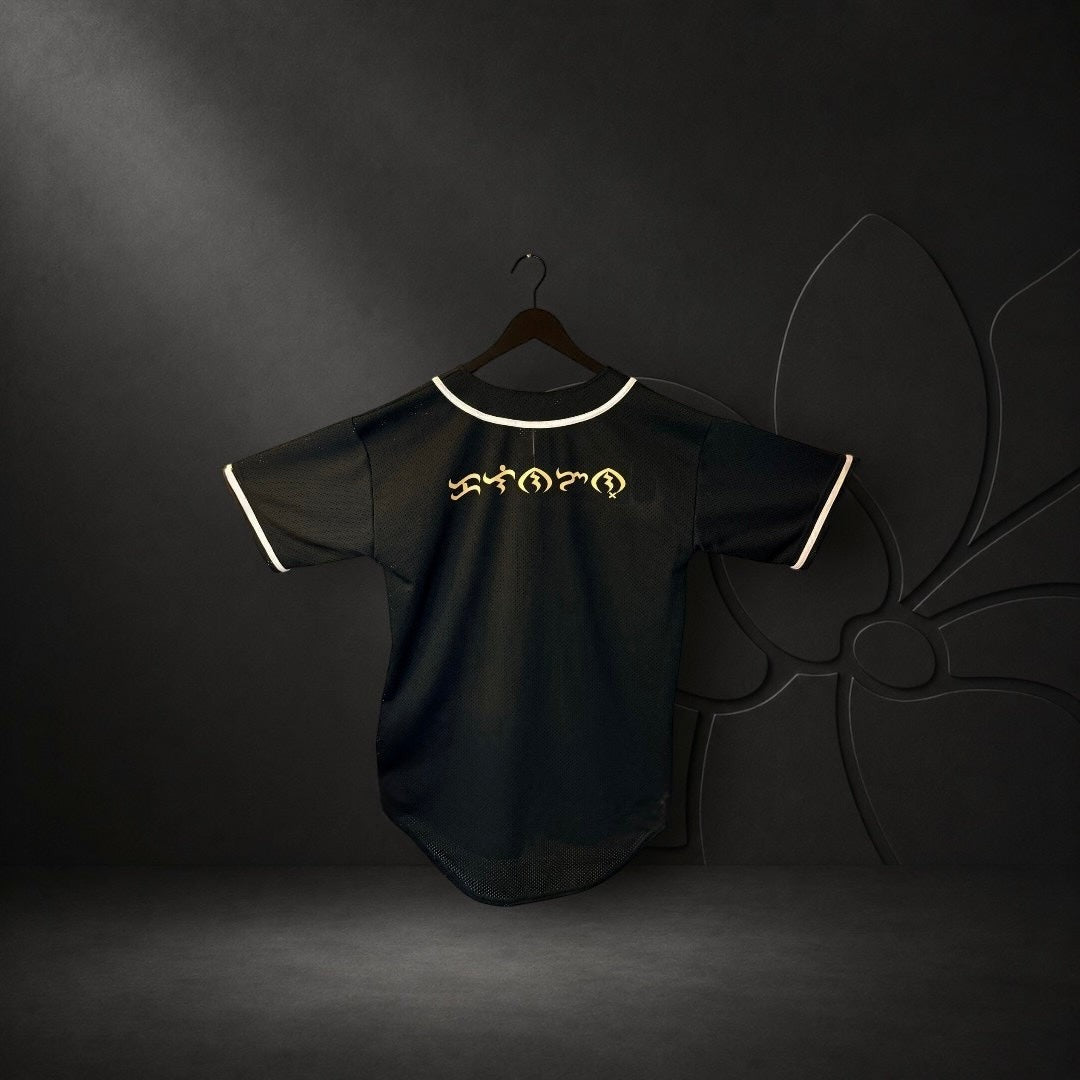 KA'EO Apparel black mesh baseball jersey with white piping and gold Baybayin script on the back.