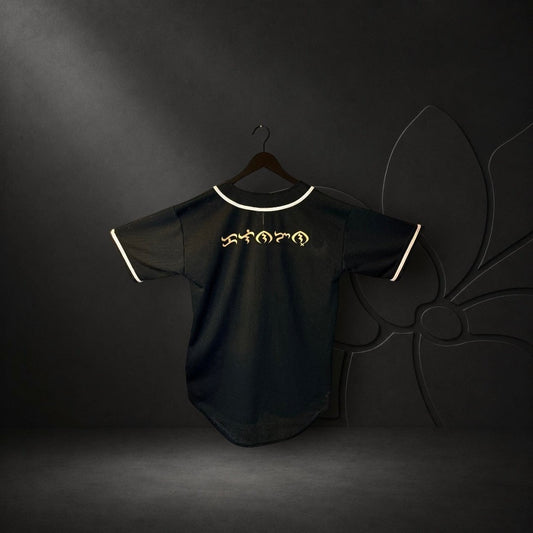 KA'EO Apparel black mesh baseball jersey with white piping and gold Baybayin script on the back.