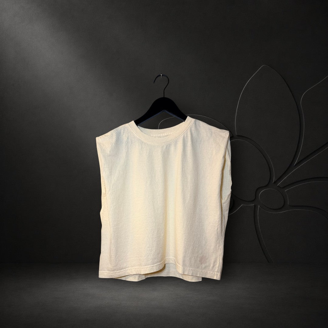 KA'EO Apparel cream crew neck muscle tank top with a relaxed fit and wide armholes hanging on a black hanger.