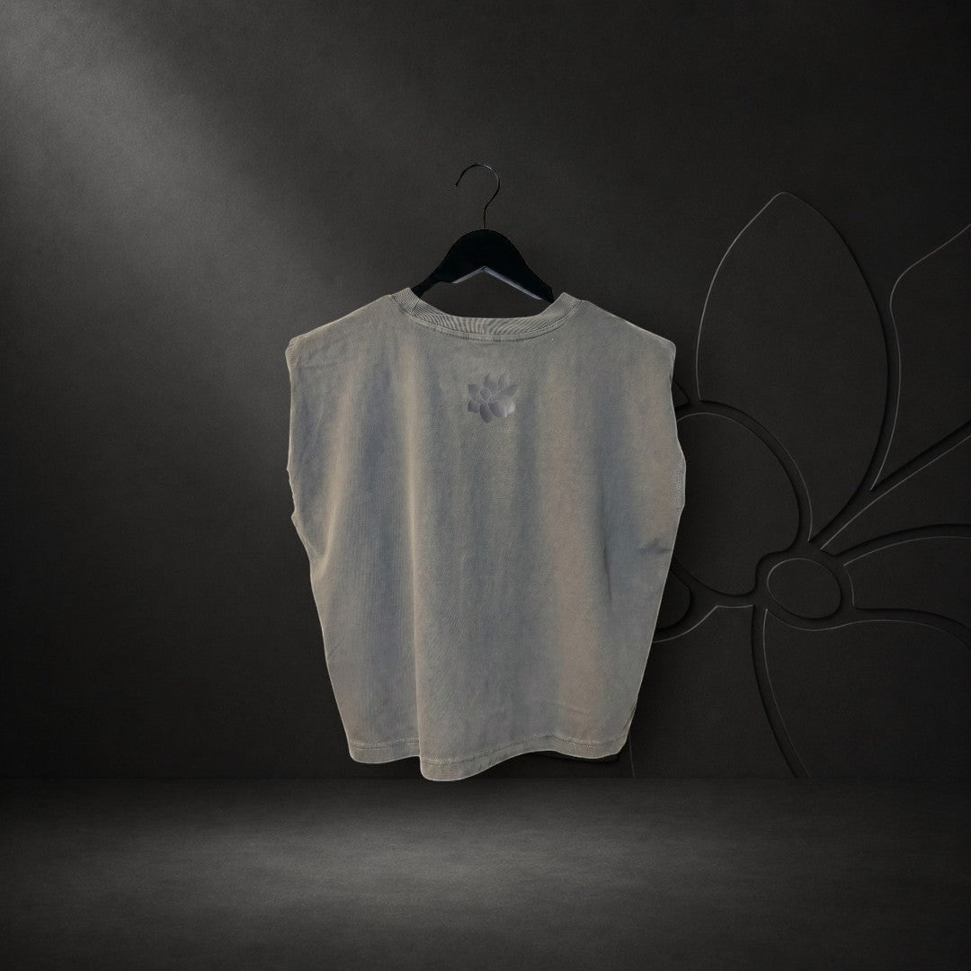 KA'EO Apparel women's faded black crew neck muscle tank top with a small sampaguita logo on the back, hanging on a hanger.