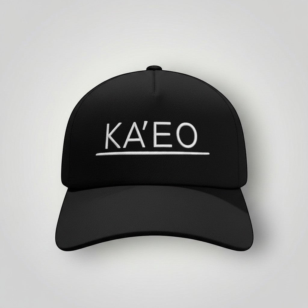 Black KA'EO Apparel snapback cap with white embroidered logo and underline detail. Structured brim, mid-profile fit.