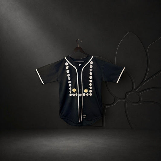 KA'EO Apparel black mesh baseball jersey featuring white piping and intricate Sampaguita floral embroidery on the front.