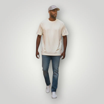 KA'EO Apparel gray embroidered snapback cap worn by a man walking on a cobblestone street.