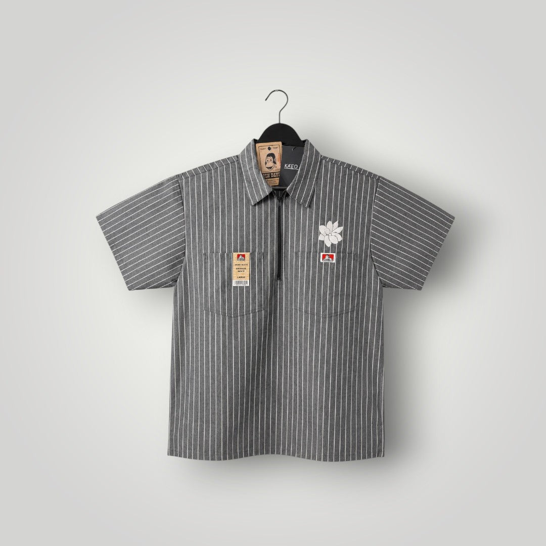 KA'EO Apparel grey pinstripe short-sleeve butcher shirt with quarter-zip, two chest pockets, and floral embroidery.