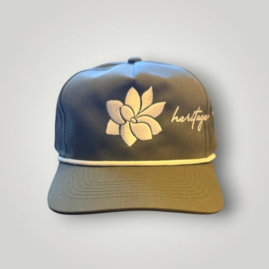 KA'EO Apparel olive green baseball cap with white embroidered Sampaguita flower and "heritage" text. Features a cream rope detail